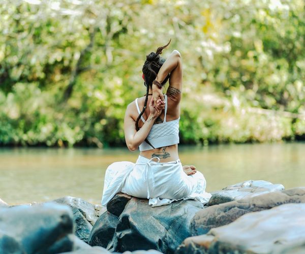 Woman meditating peacefully in a bright, natural setting.